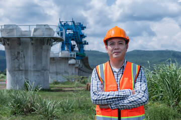worker with helmet. portrait  construction engineer with railway construction on background.