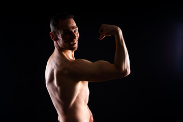 Fototapeta premium Portrait of man, bodybuilder and bicep flex in studio, background and exercise for muscular power.