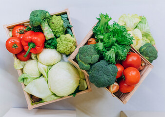Wooden box with vegetables: cabbage, pepper, broccoli, onion, tomato, green salad