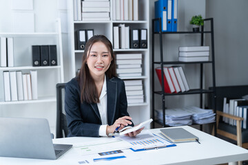 happy young businesswoman Asian siting on the chiar cheerful demeanor raise holding coffee cup smiling looking laptop screen.Making opportunities female working successful in the office.	
