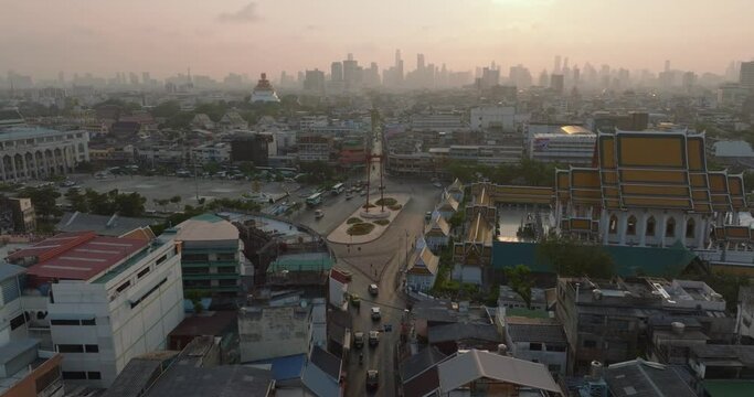 An aerial view of Red Giant Swing and Suthat Thepwararam Temple at sunset scene, The most famous tourist attraction in Bangkok, Thailand.