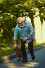 Senior man skateboarding with joy, dynamic pose and enthusiastic expression reflecting youthful...