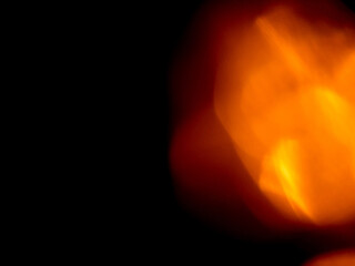 Light orange warm color light leak on dark background for design use and special effects.
