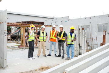 Engineers and employees standing in safety helmets working at a precast concrete wall factory.
