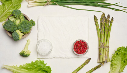 Raw asparagus, broccoli and spices on white background