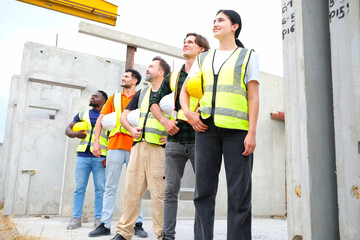 Engineers and employees standing in safety helmets working at a precast concrete wall factory.