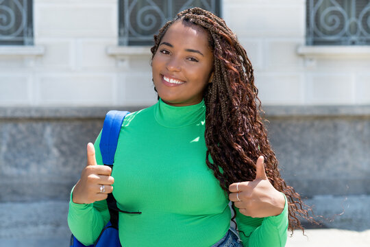 Successful black female student with dreadlocks and green shirt