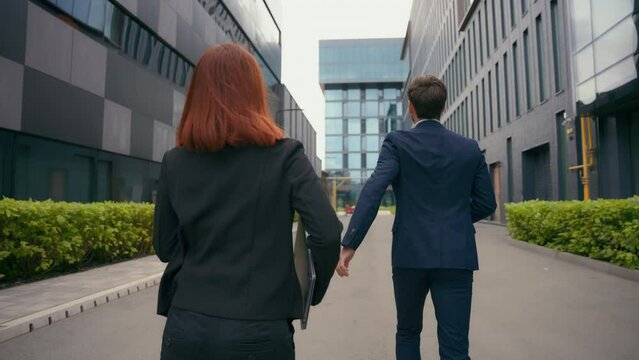 Back view worker two partners people business colleagues coworkers businessman businesswoman walk in city late man motivate woman hurry rush running to urgent meeting at office run together hurrying