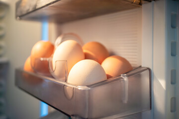 Organic eggs are stored in a transparent container inside a fridge, used as a key ingredient in...