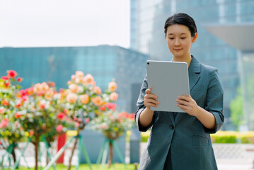 Professional Businesswoman Using Tablet in Urban Garden