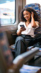 Businesswoman Commuting To Work On Train Sitting Checking Messages Or Social Media On Mobile Phone
