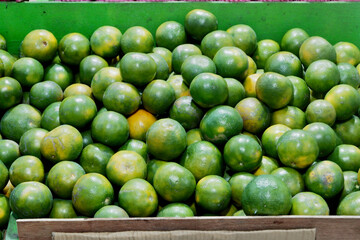 Close-Up of Fresh Green Oranges for Sale: Vibrant Citrus Display at the Market