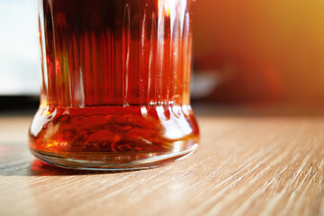 Orange drink in glass on wooden table light leak