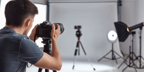 A blurred photographer is shooting in a professional photo studio with lighting equipment set up