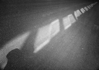 Black and white diagonal light spots on road background