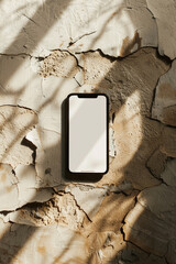 Smartphone with blank white screen on a textured plaster background with sunlight, digital phone mockup concept, Generative AI