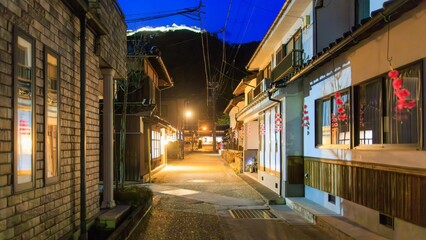 Empty narrow road in Takeda at night with lit castle on hill over town