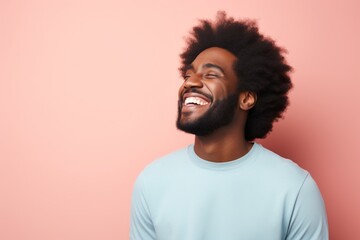 Fototapeta premium Portrait of a satisfied afro-american man in his 30s laughing in solid pastel color wall