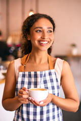 Confident Young Woman Wearing Apron Working In Coffee Shop Or Cafe