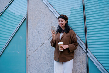 Stylish Woman Enjoying Coffee and Smartphone Outdoors
