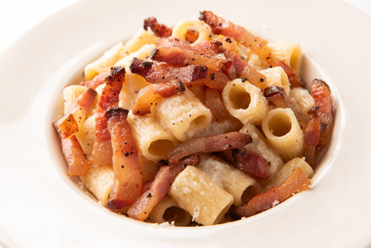 Piatto di maccheroni alla gricia, ricetta tradizionale romana di pasta condita con guanciale, pecorino e pepe nero, cibo italiano 