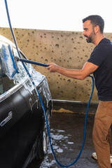 ar detailing, steam cleaning concept. Man clean car in car wash center.