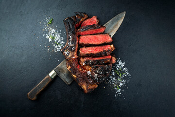 Barbecue dry aged chianina rib of beef steak served with crystal salt and thyme as top view on a...