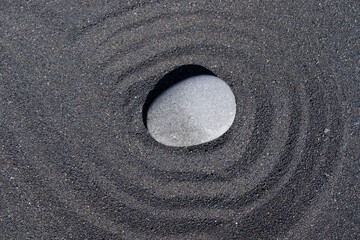 Fototapeta na wymiar Faith stone on black sand