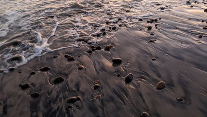 The Multi Cultural Rocks of Swamis Beach. Rounded and polished from tumbling in fast streams and ocean waves rocks of many geo ethnic origins together at Swamis Reef Surf Park Encinitas California.