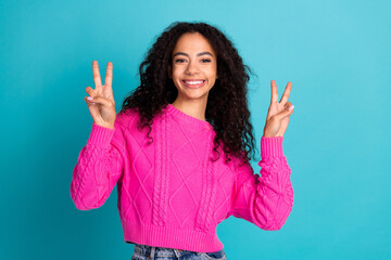 Photo of lovely young girl demonstrate v-sign wear pink pullover isolated on teal color background