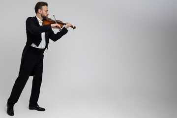 Elegant man violinist on stage performing concert