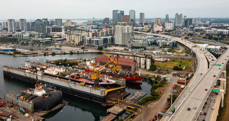 Aerial view of Tampa Florida skyline on a cloudy hazy day with shipyard and dry docked ship.