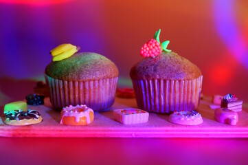 Sweet muffin decorated with raspberries and banana on a colored background.