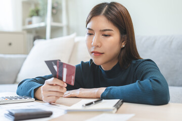 Naklejka premium Business financial concept, stressed asian young business woman hand holding credit card for calculate accounting expense of bill, tax for payment on due deadline, trying to find money to pay debt.
