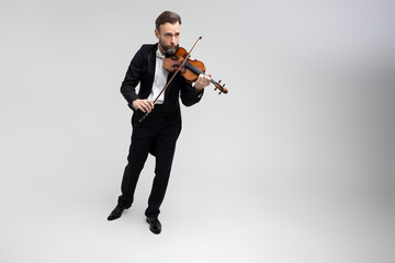 Bearded man passionate violin player at classical music performance