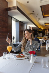 Woman taking selfie in the restaurant while