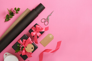 Spring gift wrapping. Brown craft wrapping paper, pink ribbon, scissors, hawthorn flowers. Copyspace