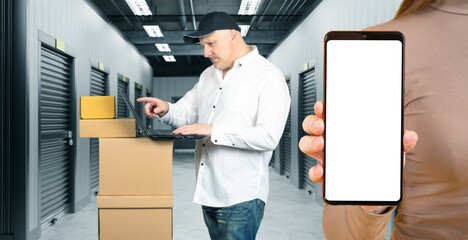 Man near storage units. Phone mock up. Guy brought boxes to warehouse. Storage units for...