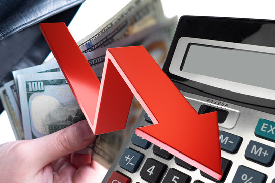 Financial crisis. Decrease in income. Down arrow near calculator. Crisis chart. Hands with money. Arrow symbolizes decrease in living standards. Crisis background. Recession, depression, problems