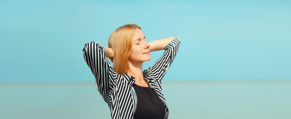 Summer vacation, happy relaxing woman meditates on the beach on sea