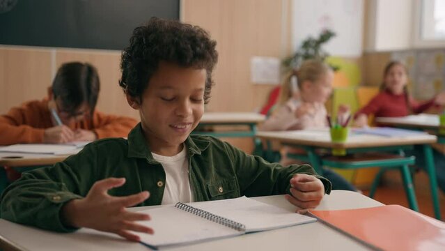 African American school boy son child guy little kid schoolboy pupil student study learn elementary education studying learning class lesson answer teacher question talk nod head yes talking agree