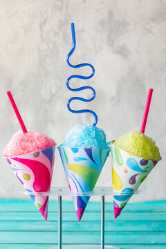 Colourful snow cones in a stand against a light background.