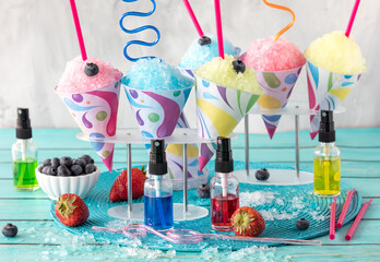 Various homemade snow cones with crazy straws, ready for sharing.