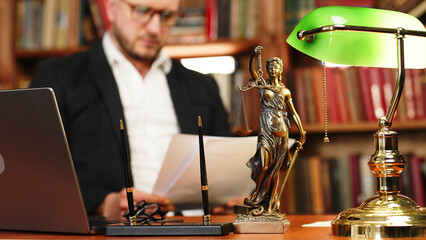 Justice and law concept. Lawyer works with laptop in court office. Concept of legal work, litigation.