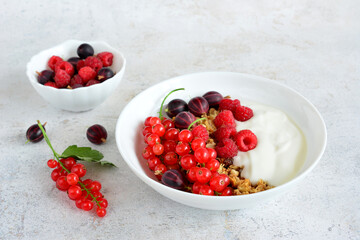 a bowl of berries and yogurt on the marble table close up