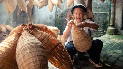 Vietnamese fishermen are doing basketry for fishing equipment at morning in Thu Sy Village, Vietnam.