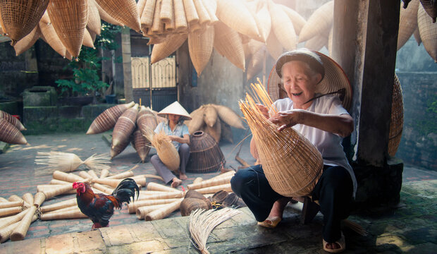 Vietnamese fishermen are doing basketry for fishing equipment at morning in Thu Sy Village, Vietnam.
