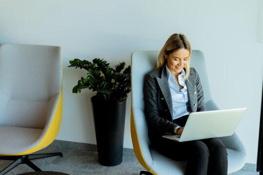 Businesswoman working on a laptop in modern office lounge