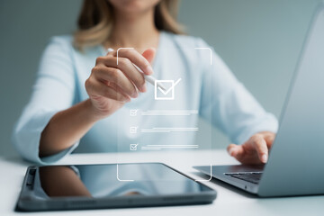 Online surveys and online assessments, A woman using a tablet and laptop to gather quantitative and qualitative business data.