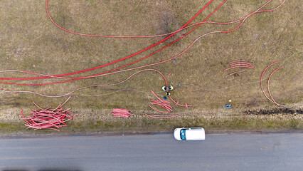 Drone photography of construction workers, industrial machinery laying new pipeline near a road...